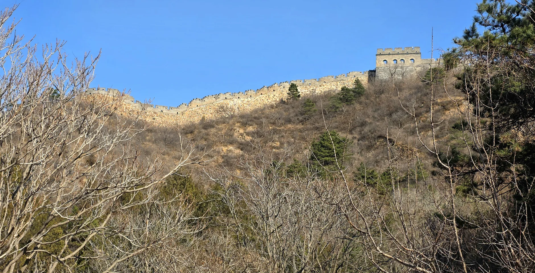 Jinshanling Great Wall running along a broad mountain ridge with watchtowers