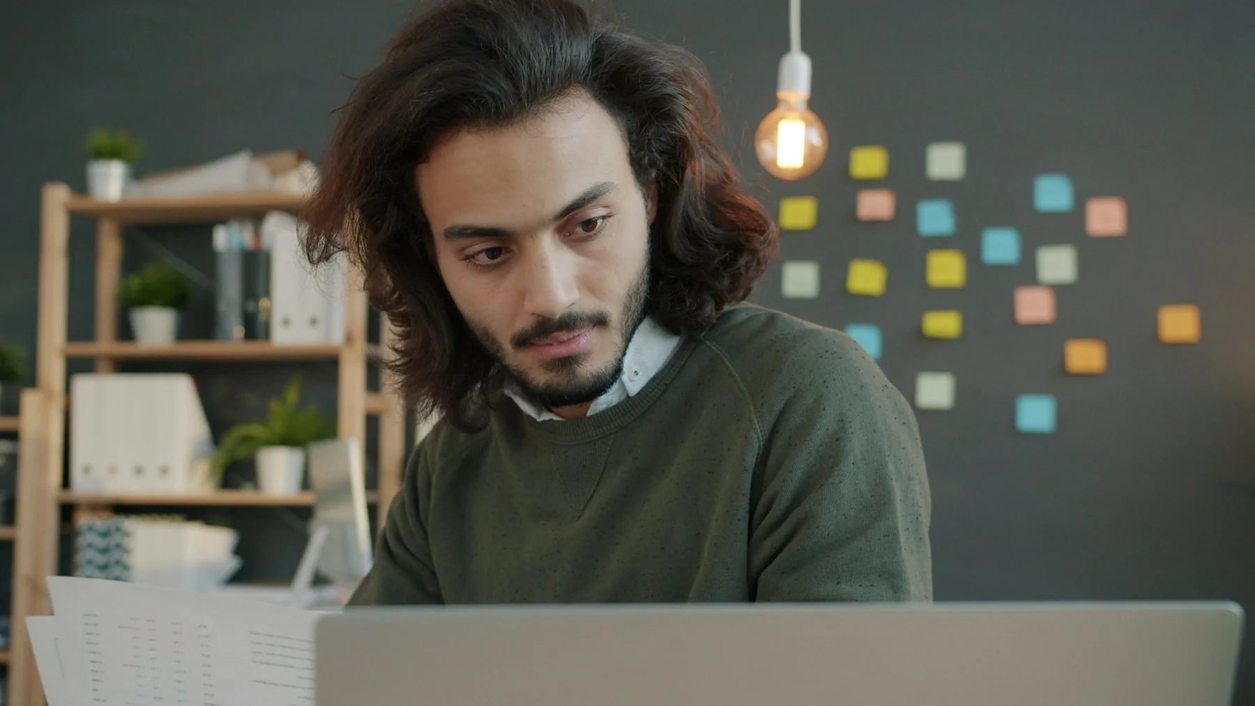 Person reviewing documents at a desk, representing invitation or host evidence